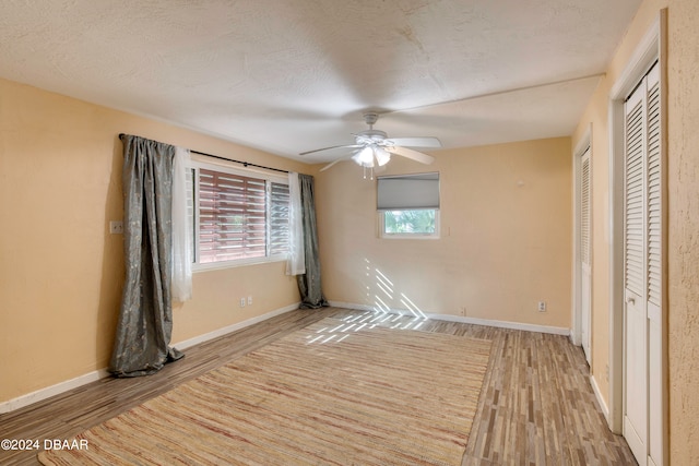 unfurnished bedroom featuring a textured ceiling, ceiling fan, and light hardwood / wood-style flooring