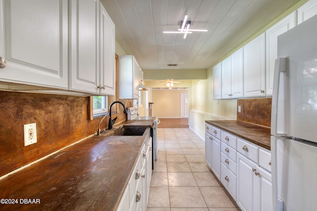 kitchen featuring white cabinets, light tile patterned flooring, ceiling fan, and white refrigerator