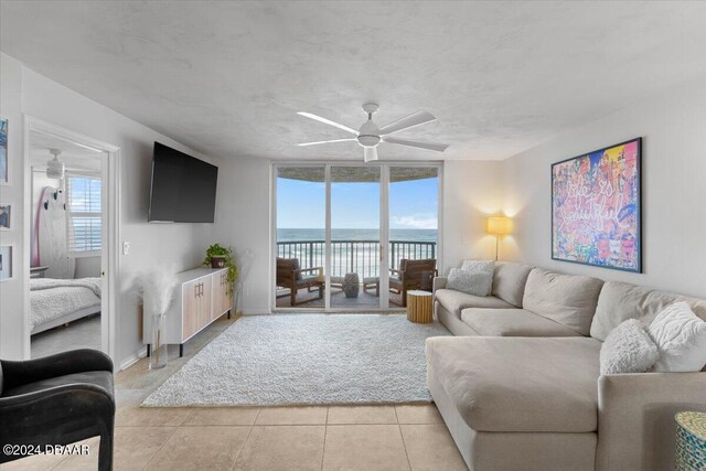 living room featuring a wealth of natural light, light tile patterned floors, and ceiling fan