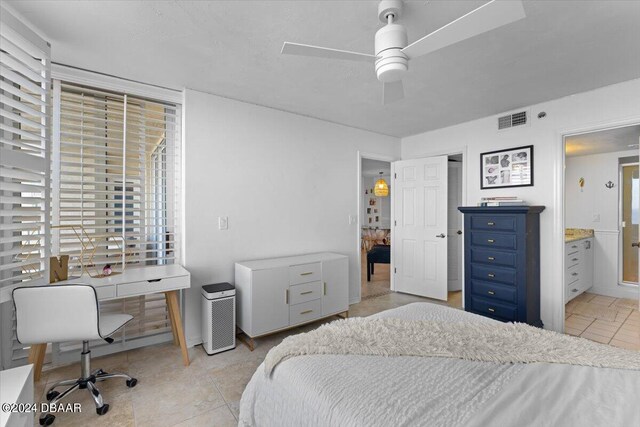 bedroom featuring ensuite bathroom, ceiling fan, and light tile patterned floors