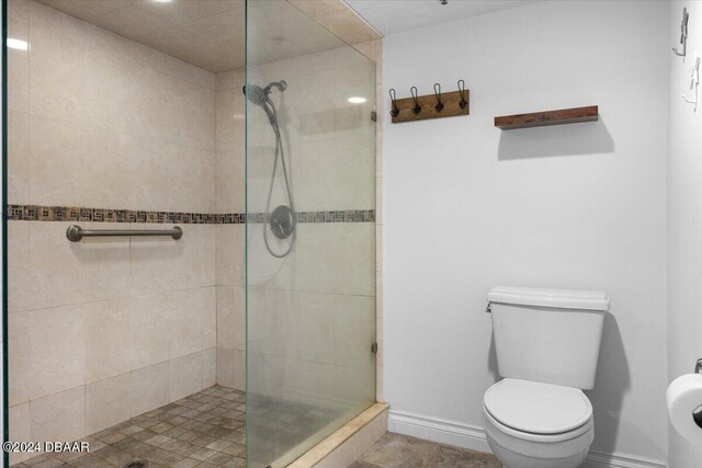 bathroom featuring toilet and tiled shower