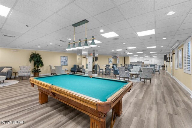 recreation room with pool table, a drop ceiling, and light hardwood / wood-style flooring