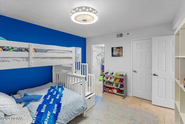 bedroom featuring a closet, a walk in closet, and light tile patterned floors