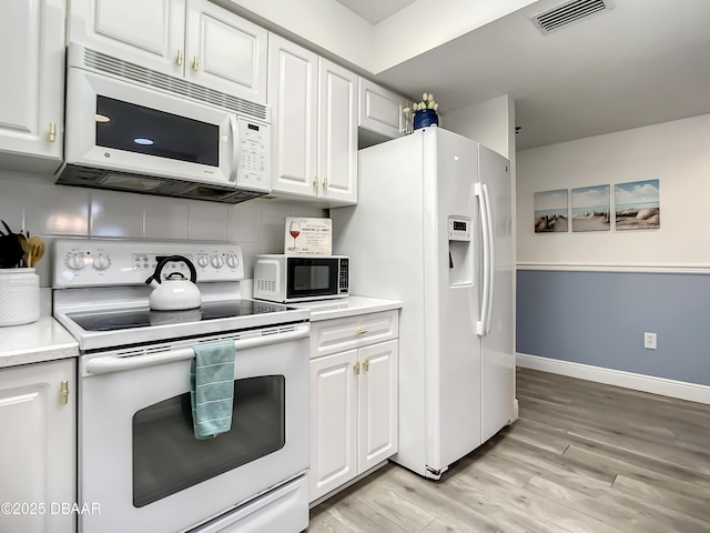 5300 S Atlantic Ave Unit 10-205, New Smyrna Beach, FL 32168 - kitchen with visible vents, white appliances, light countertops, and white cabinets