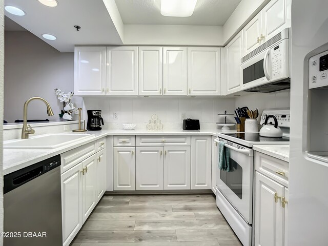 5300 S Atlantic Ave Unit 10-205, New Smyrna Beach, FL 32168 - kitchen featuring light wood-type flooring, a sink, white cabinets, and white appliances