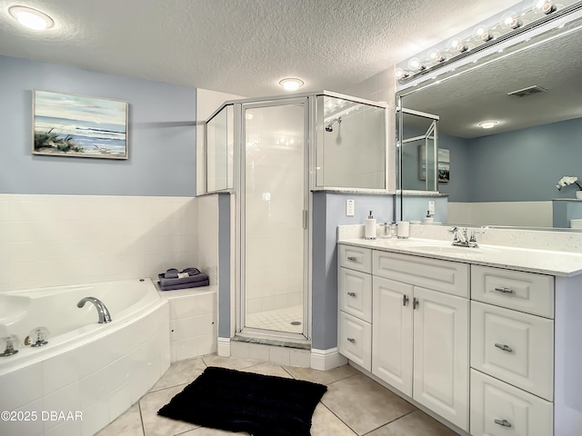 5300 S Atlantic Ave Unit 10-205, New Smyrna Beach, FL 32168 - bathroom with a textured ceiling, a bath, a stall shower, and tile patterned flooring