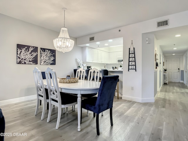 5300 S Atlantic Ave Unit 10-205, New Smyrna Beach, FL 32168 - dining room with a notable chandelier, light wood finished floors, visible vents, and baseboards