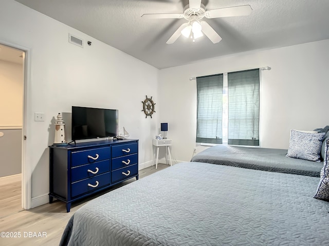 5300 S Atlantic Ave Unit 10-205, New Smyrna Beach, FL 32168 - bedroom with ceiling fan, visible vents, light wood-style flooring, baseboards, and a textured ceiling