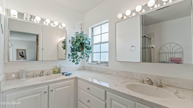 bathroom featuring a shower with door and vanity