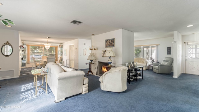 living room featuring an inviting chandelier and dark colored carpet