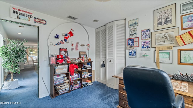 home office featuring dark colored carpet and a textured ceiling