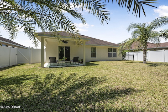 43 Pergola Pl, Ormond Beach, FL 32174 - back of property with a gate, a fenced backyard, a yard, stucco siding, and ceiling fan