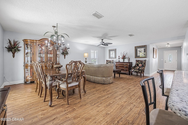 43 Pergola Pl, Ormond Beach, FL 32174 - dining room featuring a textured ceiling, light wood-style flooring, visible vents, and ceiling fan with notable chandelier