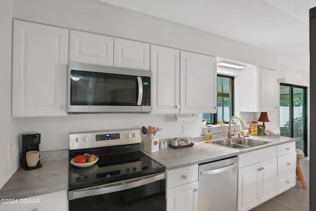 kitchen featuring white cabinetry, hardwood / wood-style flooring, stainless steel appliances, and sink