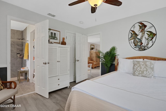 bedroom featuring hardwood / wood-style floors, ensuite bath, and ceiling fan