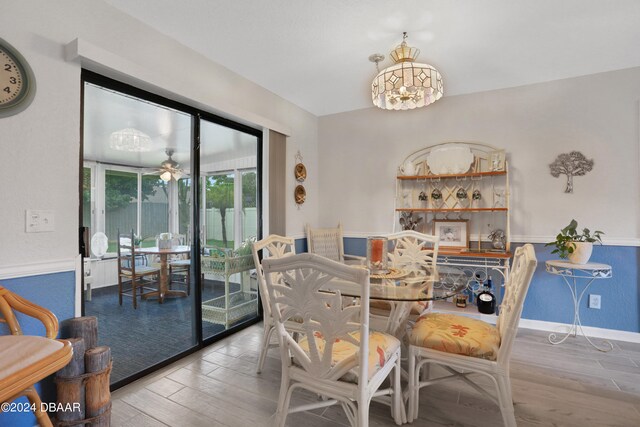 dining room featuring hardwood / wood-style flooring and ceiling fan with notable chandelier