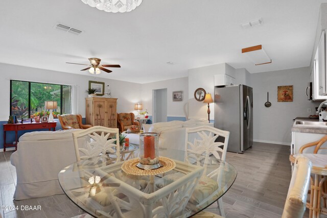 dining area with ceiling fan and light wood-type flooring