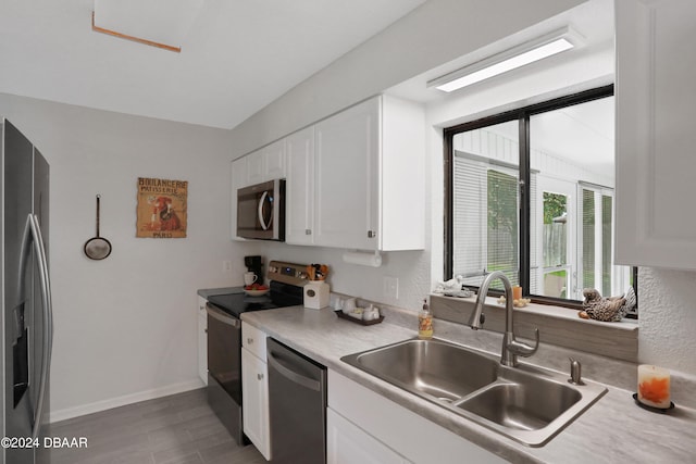 kitchen featuring white cabinetry, hardwood / wood-style floors, appliances with stainless steel finishes, and sink