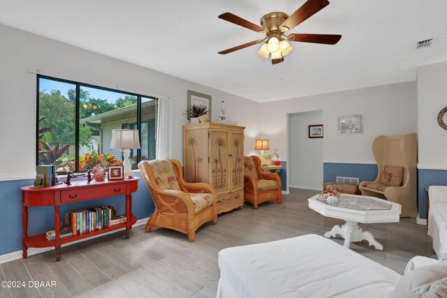 living area featuring light wood-type flooring and ceiling fan