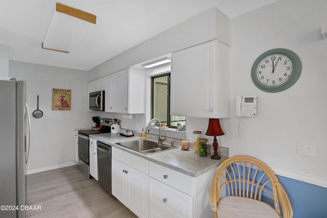 kitchen with white cabinets, sink, light hardwood / wood-style floors, and stainless steel appliances