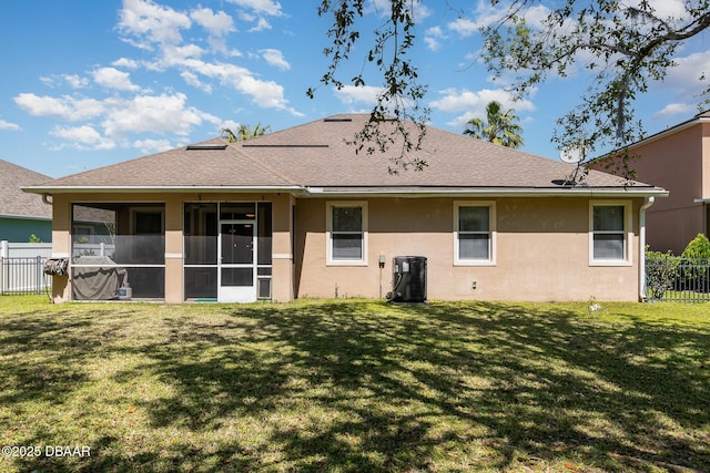 137 Boysenberry Ln, Daytona Beach, FL 32124 - back of house featuring a sunroom, stucco siding, roof with shingles, fence, and a lawn