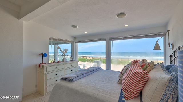 bedroom with a textured ceiling and a water view