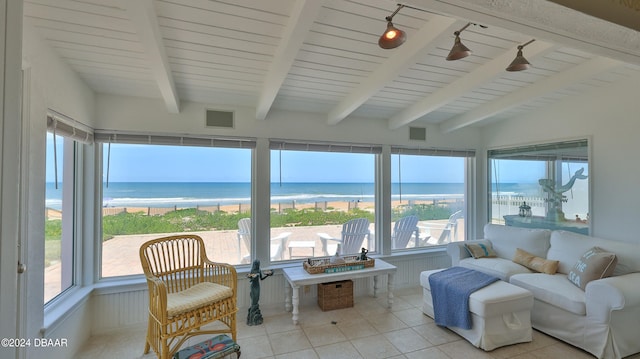 sunroom featuring a wealth of natural light, a view of the beach, a water view, and vaulted ceiling with beams