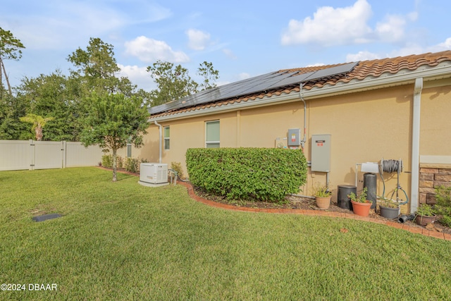 exterior space with solar panels and a yard