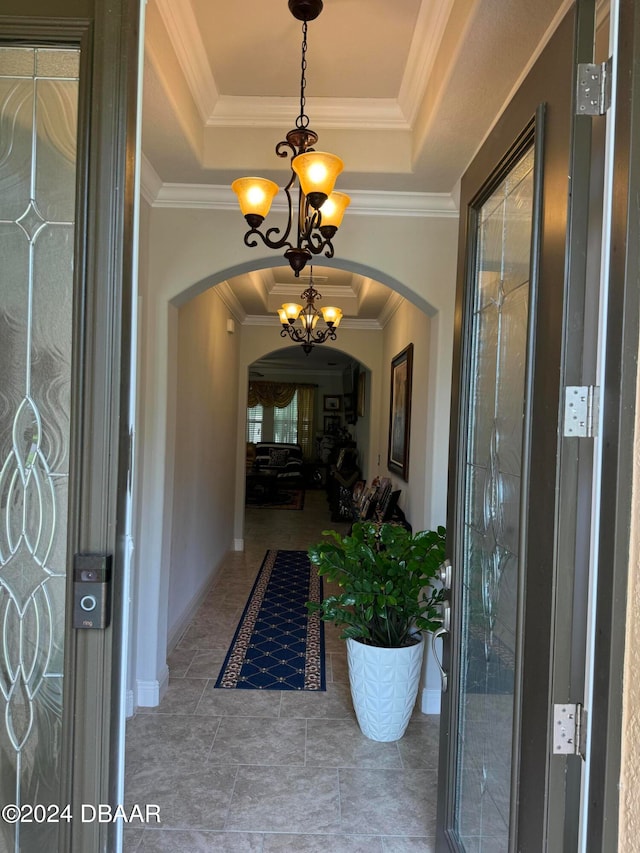 interior space featuring ornamental molding, a raised ceiling, and an inviting chandelier