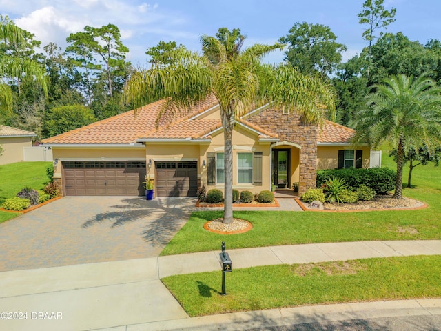 mediterranean / spanish house featuring a front lawn and a garage