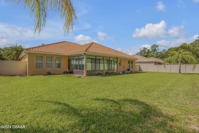 back of house with a sunroom and a yard