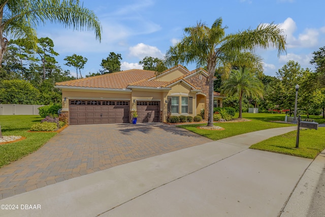 mediterranean / spanish home with a garage and a front yard