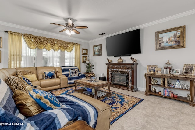 living room with a high end fireplace, ceiling fan, and crown molding