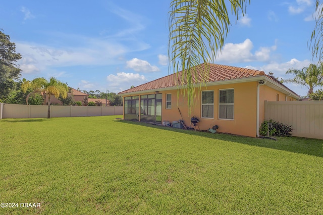 rear view of house with a sunroom and a yard