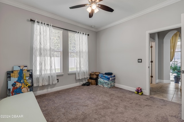 rec room with carpet flooring, ornamental molding, and ceiling fan