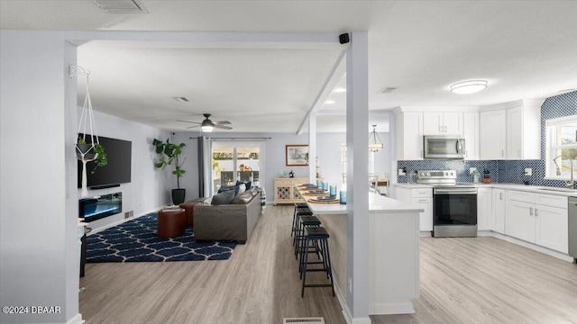 kitchen with plenty of natural light, appliances with stainless steel finishes, and light hardwood / wood-style flooring