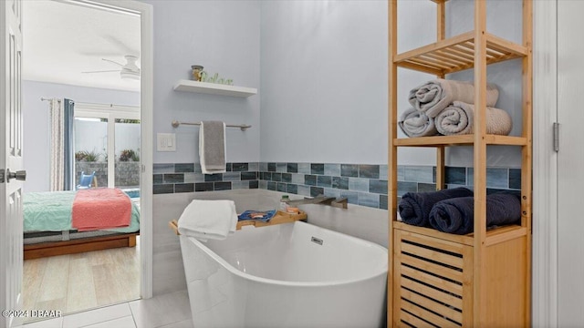 bathroom featuring tile patterned flooring, ceiling fan, and a tub to relax in