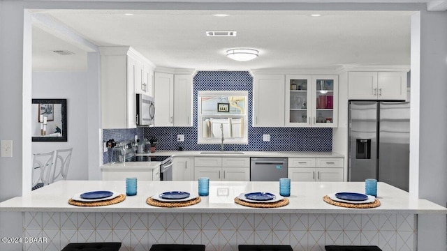 kitchen featuring light stone countertops, sink, white cabinetry, and stainless steel appliances