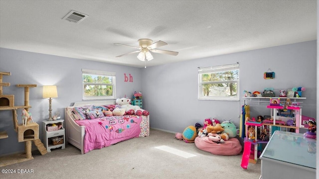 bedroom with carpet, ceiling fan, a textured ceiling, and multiple windows