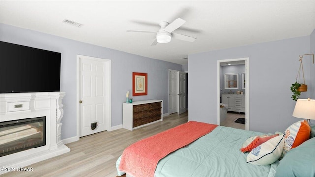 bedroom with connected bathroom, light hardwood / wood-style floors, and ceiling fan