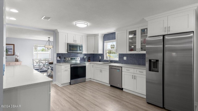 kitchen with light hardwood / wood-style flooring, stainless steel appliances, white cabinetry, and sink