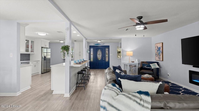 living room featuring ceiling fan and light wood-type flooring