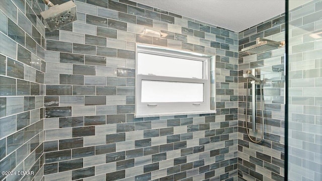 bathroom featuring a textured ceiling and tiled shower