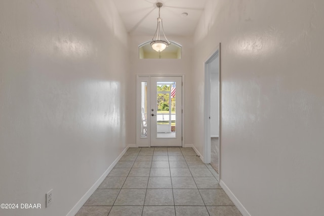 entryway with high vaulted ceiling and light tile patterned floors