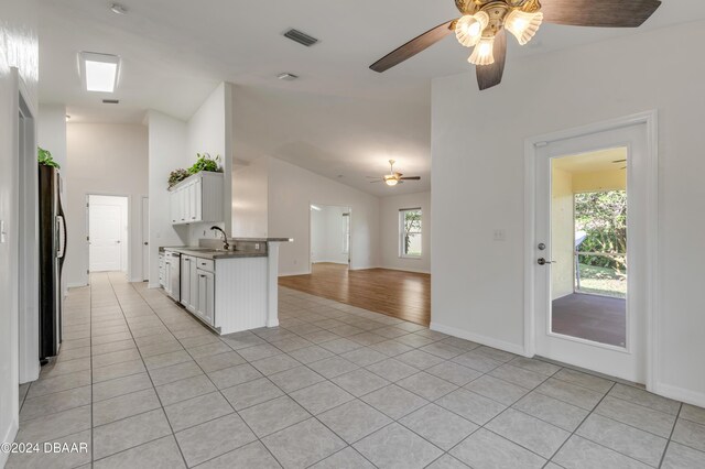 2853 Turnbull Estates Dr, New Smyrna Beach, FL 32168 - kitchen with white cabinets, a healthy amount of sunlight, stainless steel fridge with ice dispenser, and sink