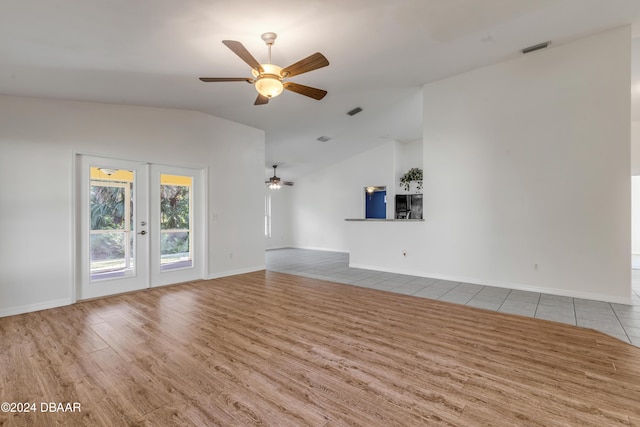 2853 Turnbull Estates Dr, New Smyrna Beach, FL 32168 - unfurnished living room featuring french doors, light wood-type flooring, vaulted ceiling, and ceiling fan