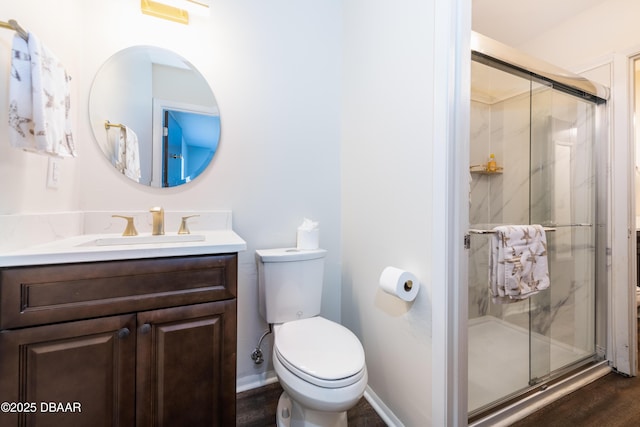 bathroom featuring an enclosed shower, vanity, and toilet