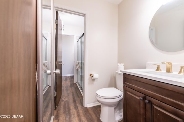 bathroom with wood-type flooring, vanity, toilet, and walk in shower