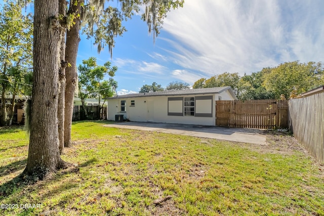 back of property with a patio and a yard