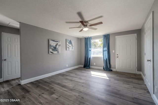 spare room with ceiling fan, wood-type flooring, and a textured ceiling